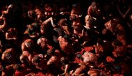 Revelers play in tomato pulp during the annual 