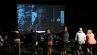 People pedal stationary bikes and generate up to 50% of the energy at a pop-up outdoor cinema in a park in Warsaw, Poland September 2, 2022. Reuters/Kacper Pempel