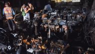 Police officials stand amidst damaged scooters after a fire broke out at an electric scooter showroom in the southern city of Secunderabad, India, September 13, 2022. REUTERS/Stringer