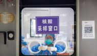 A pandemic prevention worker sits in a nucleic acid testing booth following a coronavirus disease (Covid-19) outbreak in Beijing, China, September 13, 2022. (REUTERS/Thomas Peter)