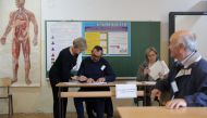 A woman signs before voting during presidential and parliamentary elections at a polling centre in a school in Livno, Bosnia and Herzegovina October 2, 2022. Reuters/Dado Ruvic