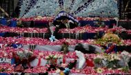 Petals and Arema FC supporters' attributes are placed on a monument to pay condolence to the victims of a riot and stampede following a soccer match between Arema FC and Persebaya Surabaya teams, outside the Kanjuruhan Stadium, in Malang, East Java province, Indonesia, October 3, 2022. REUTERS/Willy Kurniawan