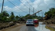 Cars drive under a downed power pole in the aftermath of Hurricane Fiona in Santa Isabel, Puerto Rico September 21, 2022. REUTERS/Ricardo Arduengo/File Photo


