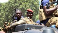 Burkina Faso's new military leader Ibrahim Traore is escorted by soldiers while he stands in an armoured vehicle in Ouagadougou, Burkina Faso, on October 2, 2022. (REUTERS/Vincent Bado)