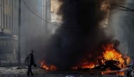 A driver walks near his burned car after Russian military strike, as Russia's invasion of Ukraine continues, in central Kyiv, Ukraine, October 10, 2022. (REUTERS/Gleb Garanich)