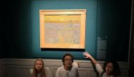 Activists of 'Ultima Generazione (Last Generation)' glue their hands to the wall after throwing soup at a van Gogh's painting 'The Sower' at Palazzo Bonaparte in Rome, Italy, November 4, 2022. (Arthemisia/Handout via REUTERS)