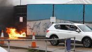 A man throws an object out of a car window next to the Border Force centre after a firebomb attack in Dover, Britain, October 30, 2022. Reuters/Peter Nicholls
