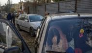 A Ukranian woman sits in a car with her family after they managed to flee from the Russian occupied territory of Kherson, on November 5, 2022, in Zaporizhzhia. (Photo by BULENT KILIC / AFP)