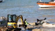 Rescue team members remove a car from the water following a landslide on the Italian holiday island of Ischia, Italy November 27, 2022. REUTERS/Ciro De Luca