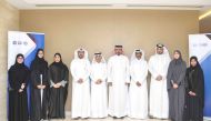 QNB officials and Qatar Banking Studies and Business Administration Secondary School students pose for a group photo.