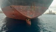 Three stowaway migrants are seen on the rudder blade of petrol vessel Althini II after traveling from Nigeria and before being rescued by Spanish coast guard, in this picture released on the Salvamento Maritimo official Twitter account. Salvamento Maritimo/Handout via Reuters 