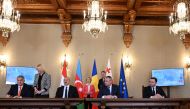 (From left) Hungary's Prime Minister Viktor Orban, Azerbaijan's President Ilham Aliyev, Romanian Prime Minister Nicolae Ciuca and Georgian Prime Minister Irakli Garibashvili sign an Agreement on Strategic Partnership in the Field of Green Energy Development and Transmission between the governments, while European Commission President Ursula von der Leyen and Romanian President Klaus Iohannis are seen in the background, at the presidential Cotroceni Palace in Bucharest on December 17, 2022. (Photo by Daniel MIHAILESCU / AFP)