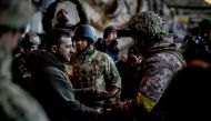 In this handout picture taken and released on December 20, 2022 by the Ukrainian Presidential press services Ukraine President Volodymyr Zelensky (left) hands out the State Award to a soldier during a medal giving ceremony to Ukrainian servicemen who have been holding back a fierce and months-long Russian military campaign for the city, as part of Zelensky's visit in the eastern frontline city of Bakhmut, now the epicentre of fighting in Russia's nearly 10-month invasion of Ukraine. (Photo by STRINGER / UKRAINIAN PRESIDENTIAL PRESS SERVICE / AFP)