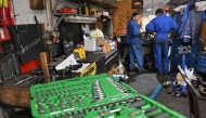 Mechanics work in a auto repairing shop in Ukrainian capital of Kyiv on December 30, 2022. Photo by Sergei SUPINSKY / AFP