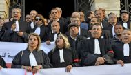 Tunisian lawyers wear a red armband during a lawyers sit in protest against the new finance law, in front of the Tunis court, on January 5, 2023. (Photo by FETHI BELAID / AFP)