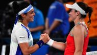 Tunisia's Ons Jabeur (left) shakes hands with Slovenia's Tamara Zidansek after their women's singles match on day two of the Australian Open tennis tournament in Melbourne on January 17, 2023. (Photo by Paul CROCK / AFP)