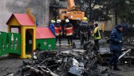 Firefighters work near the site where a helicopter crashed near a kindergarten in Brovary, outside the capital Kyiv, killing Sixteen people, including two children and Ukrainian interior minister, on January 18, 2023, amid the Russian invasion of Ukraine. (Photo by Sergei Supinsky / AFP)
