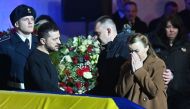 Ukrainian President Volodymyr Zelenskyy offers relatives his condolences during the funeral ceremony of Ukrainian Interior Minister Denys Monastyrsky and other employees of his department at the Ukrainian House in Kyiv on January 21, 2023. (Photo by Sergei SUPINSKY / AFP)