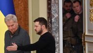 Ukrainian security officers look out from a door as Ukrainian President Volodymyr Zelensky greets his Finnish counterpart Sauli Niinisto (left) to their joint press conference following talks in Kyiv, on January 24, 2023, amid Russia's military invasion on Ukraine. (Photo by Sergei Supinsky / AFP)