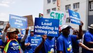 Democratic Alliance (DA) members hold placards as they march to Luthuli House, the headquarters of the ruling african National Congress (ANC), during a protest against prolonged energy crisis that has seen South africans experience record power cuts, in Johannesburg on January 25, 2023. (Photo by PHILL MAGAKOE / AFP)
