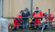 Rescue workers attend to a wounded person near a railway crossing at the station of Brokstedt, northern Germany, on January 23, 2023, after a man stabbed people on a regional train between the cities of Hamburg and Kiel, killing two people and wounding several others. (Photo by Jonas Walzberg / dpa / AFP) / Germany OUT

