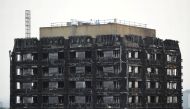 Workers stand on the roof of the burnt out remains of the Grenfell tower in London, Britain, on October 16, 2017. File Photo / Reuters
