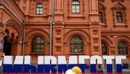 A woman walks past huge letters reading 
