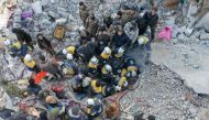 An aerial picture shows rescuers searching the rubble of buildings for casualties and survivors in the village of Besnaya in Syria's rebel-held northwestern Idlib province at the border with Turkey following an earthquake, on February 7, 2023. (Photo by Omar Haj Kadour / AFP)