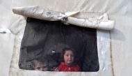 Syrian children look out of the window of a tent window at an emergency shelter in the center of the city of Maarat Misrin, in the rebel-held northern part of the northwestern Idlib province one day after a deadly earthquake hit Syria and Turkey, on February 7, 2023. (Photo by Abdulaziz Ketaz / AFP)