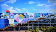 This photograph taken on February 8, 2023, shows an illustration of the dominant colours and visual identity on the Centre Pompidou, displayed on a screen during the presentation of the pictograms of each discipline and visual identity of Paris 2024 and Olympic and Paralympic Games, in Saint-Denis, north of Paris. (Photo by FRANCK FIFE / AFP)