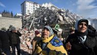 Women react as they wait for a rescue team next to their collapsed building in the southeastern Turkish city of Kahramanmaras, on February 8, 2023. (AFP)
