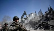 Turkish soldiers patrol next to collapsed buildings in Kahramanmaras on February 13, 2023, as rescue teams continue to search for victims and survivors, after a 7.8 magnitude earthquake struck the border region of Turkey and Syria. (Photo by OZAN KOSE / AFP)
