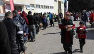 Quake-hit displaced people wait in a line to receive food at Islahiye Atatürk Stadium in Islahiye near Gaziantep on February 14, 2023, a week after a deadly earthquake struck parts of Turkey and Syria. (Photo by Zein Al RIFAI / AFP)