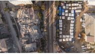 This aerial photograph taken on February 20, 2023 collapsed buildings next to a makeshift camp in Antakya, southern Turkey. (Photo by Sameer Al-DOUMY / AFP)