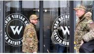 Visitors wearing military camouflage stand at the entrance of the 'PMC Wagner Centre', associated with the founder of the Wagner private military group (PMC) Yevgeny Prigozhin, during the official opening of the office block on the National Unity Day, in Saint Petersburg, on November 4, 2022. (Photo by OLGA MALTSEVA/AFP via Getty Images) 