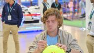 Andrey Rublev signs a giant tennis ball during his visit to ExxonMobil Qatar’s stand at Qatar ExxonMobil Open 2023 Public Village.
