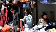 A sub-Saharan African woman (centre) looks for clothes in a thrift store in the popular Ariana souk near Tunis on February 22, 2023.  (Photo by FETHI BELAID / AFP)