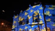 A light installation by Swiss artist Gerry Hofstetter is projected on the main Post Office building in Kyiv on February 23, 2023, on the eve of first anniversary of the Russian invasion to Ukraine. (Photo by Sergei Supinsky / AFP) 