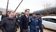 In this handout photograph taken on March 1, 2023 and released by the Greek Prime Minister's Office shows Greek transport minister, Kostas Karamanls (left) and Greek PM Kyriakos Mitsotakis (centre) visit the crash site following the deadly train accident where at least 38 people died and another 85 were injured near the Greek city of Larissa. Greece announced three days of national mourning. (Photo by Handout / AFP) 