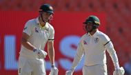 Australia's Usman Khawaja (R) and Cameron Green wear black armbands following the death of skipper Pat Cummins' mother as they wait for the start of the second day play of the fourth and final Test cricket match between India and Australia at the Narendra Modi Stadium in Ahmedabad on March 10, 2023. (Photo by Punit PARANJPE / AFP)