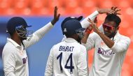India's Axar Patel (R) celebrates with teammates after taking the wicket of Australia's Travis Head (not pictured) during the fifth day of the fourth and final Test cricket match between India and Australia at the Narendra Modi Stadium in Ahmedabad on March 13, 2023. (Photo by Punit Paranpe / AFP)