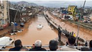 People stand at a high pont looking down at the flood waters in Sanliurfa, southeastern Turkey on March 15, 2023. (AFP)