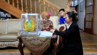 A woman votes at her home during parliamentary elections in Almaty on March 19, 2023. (Photo by Ruslan Pryanikov / AFP)