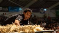 In this file photo taken on March 04, 2023, Joel Henare from Gisborne casts a fleece as he competes in the wool handlers section during the Golden Shears International sheep shearing competition at The Wool Shed in Masterton. 
