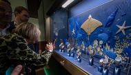 Participants watches a showcase at the Rolex booth on the opening day of luxury watch fair 'Watches and Wonders Geneva', on March 27, 2023 in Geneva. (Photo by Fabrice Coffrini / AFP)