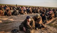 Men suspected of being Islamic State fighters wait to be searched by members of the Kurdish-led Syrian Democratic Forces after leaving the group's last holdout of Baghouz, Syria, on Feb. 22. (Bulent Kilic/AFP/Getty Images)