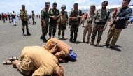 Returned Houthi prisoners exchanged in a deal Yemen's internationally recognised-government prostrate in prayer on the tarmac upon arrival at Sanaa International Airport on April 14, 2023. (Photo by MOHAMMED HUWAIS / AFP)