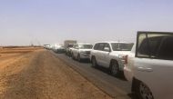 A convoy leaving Khartoum advances on a road towards Port Sudan, on April 23, 2023, as people flee the battle-torn Sudanese capital. (Photo by Abubakarr JALLOH / AFP)