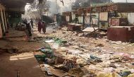 People walk among scattered objects in the market of El Geneina, the capital of West Darfur, as fighting continues in Sudan between the forces of two rival generals, on April 29, 2023.  Photo by AFP
