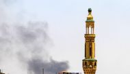 Smoke billows above buildings behind a mosque during fighting between the forces of two rival Sudanese generals in Khartoum, on May 5, 2023. (Photo by AFP)